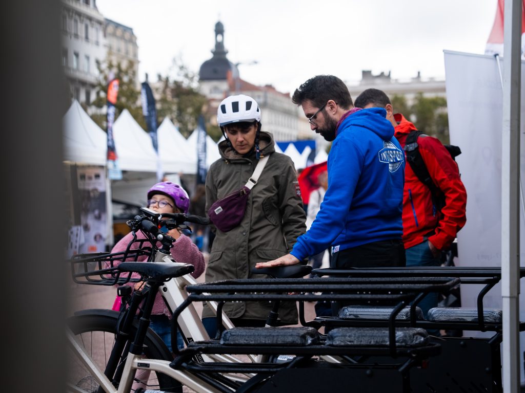 Équipe de Second Cycle conseillant une famille pour l'achat d'un vélo cargo longtail à la bourse aux vélos de Lyon.